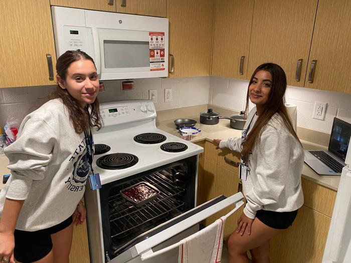 Two students cooking brownies at Lions Gate